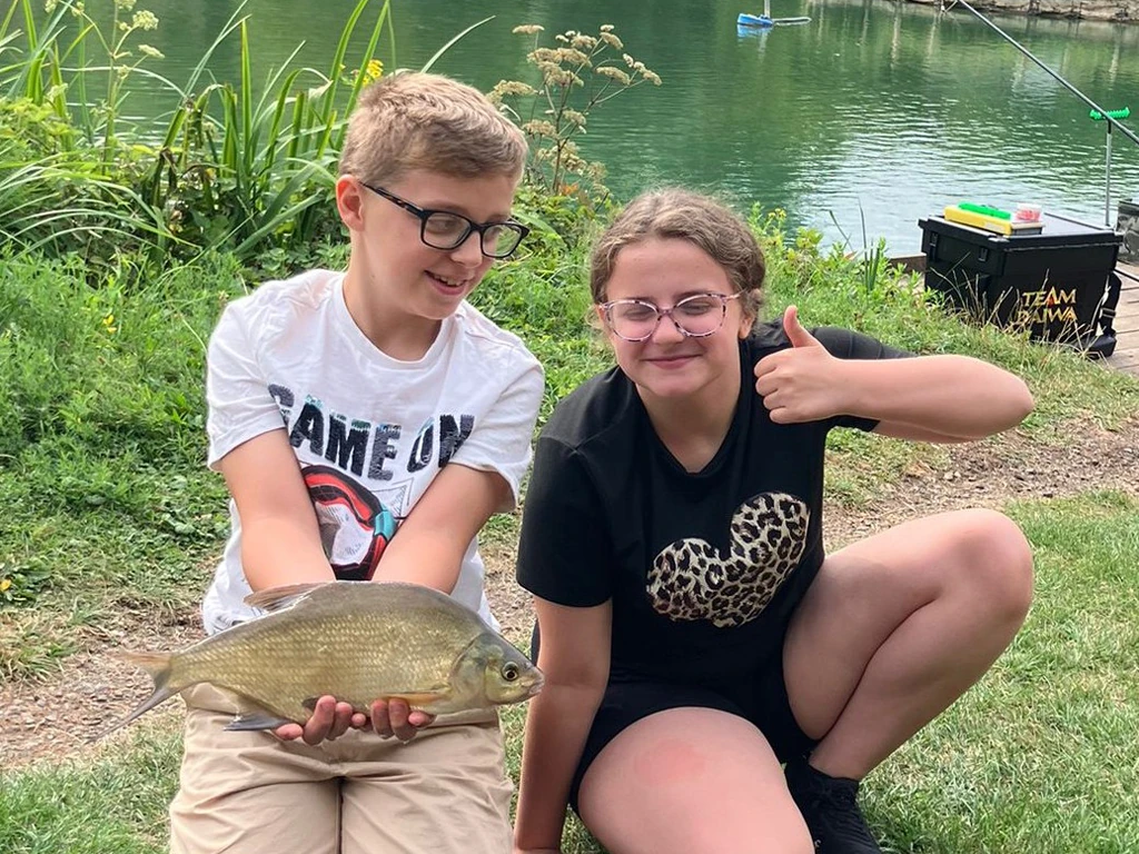 Young people holding recently caught Bream